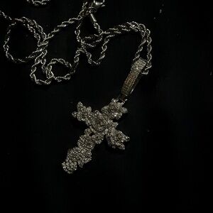 This is a iced out cross necklace and it has Roses on it.